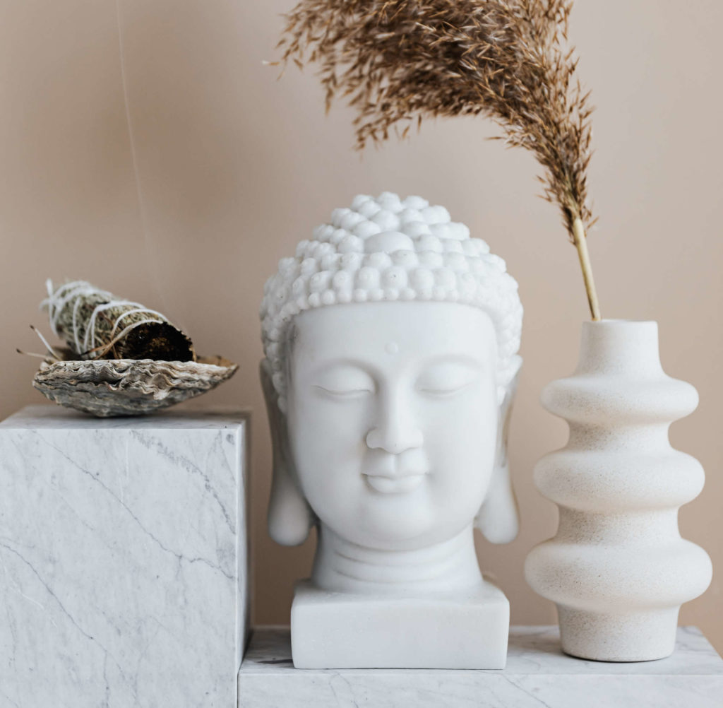 Buddha in weiß und spirituelles Räucherbündel