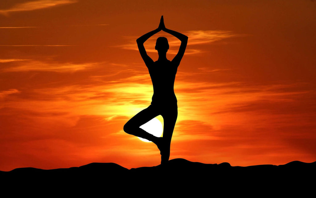 Silhouette Mensch stehende Yogaübung Sonnenuntergang